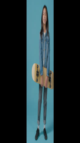 Vertical-Shot-of-Boy-Holding-Skateboard